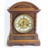 A German oak cased mantle clock by H.A.C Wurttemberg C.1900, case carved with curved pediment top