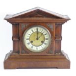 An early 20th Century oak cased mantle clock, enameled dial with roman numerals, movement striking