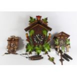 Three black forest cuckoo clocks dials stamped Germany, graduated sizes - largest 37cm long