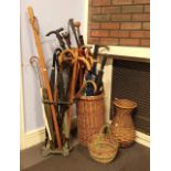 A collection of walking sticks, canes, umbrella's and staffs, complete with cast metal stand and