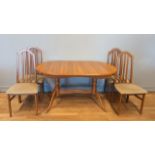 A extending dining table, light wood, with four upholstered dining chairs, together with a mid