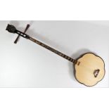 A traditional Vietnamese Dan Sen two string lute, carved flower shaped body with oriental floral