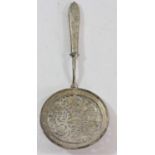 An unmarked silver decorative straining spoon, tests as .800 standard, with engraved decoration,