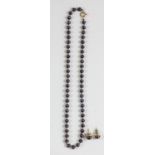 A black cultured pearl and 9ct gold bead necklace, 5mm beads, 38cm, together with a matching pair of