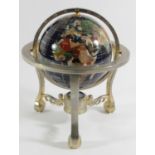 A semi precious gemstone world globe with compass, rotating in its axis on a cast brass stand.