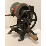 A cast iron manual grinder, two grinding wheels, adjustable tool rail, wooden handle, 32cm tall,