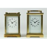 Two brassed cased manual wind mantle clocks, white enameled dials with beveled edge glass panels -