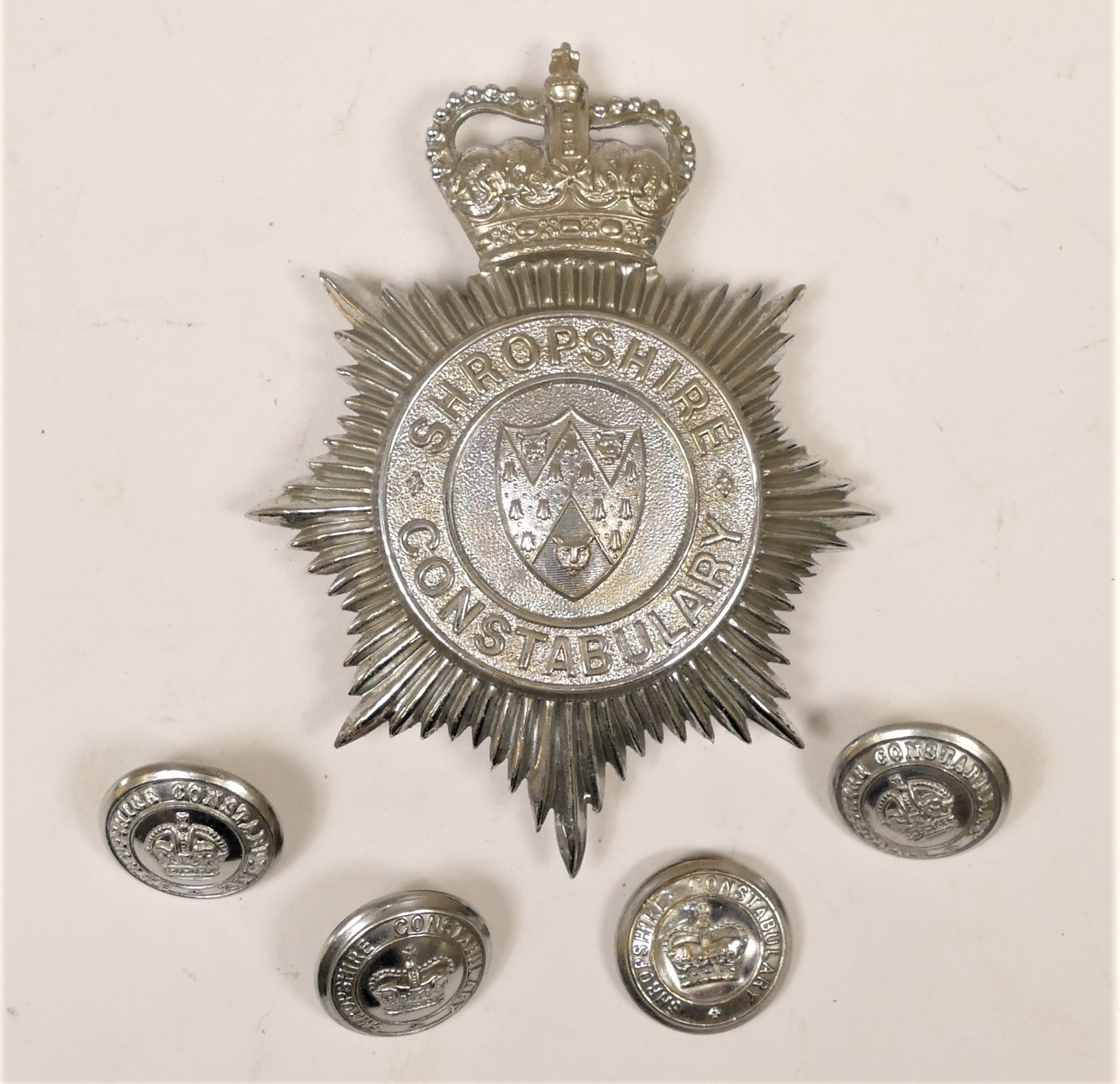 A Shropshire Constabulary helmet badge, Queen's Crown, together with four matching buttons (5)