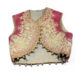 A Georgian red silk and gold wire child's waistcoat, in the Indian taste, with woven ball fringe,