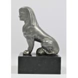 A base metal car mascot in the form of a seated Sphynx mounted on a black onyx base, 11cm.