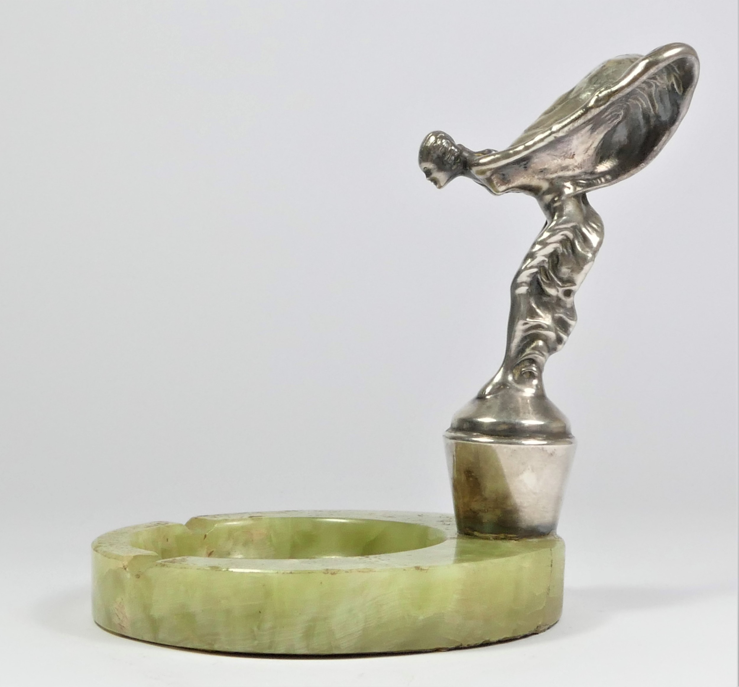 A chrome car mascot in the form of a Rolls Royce Spirit of Ecstasy mounted on a green onyx