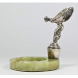 A chrome car mascot in the form of a Rolls Royce Spirit of Ecstasy mounted on a green onyx