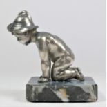 A chrome car mascot in the form of a kneeling child with hat mounted on an onyx base, 10cm.