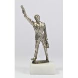 A base metal car mascot in the form of a man hailing a cab, mounted on a white onyx base, 14cm.