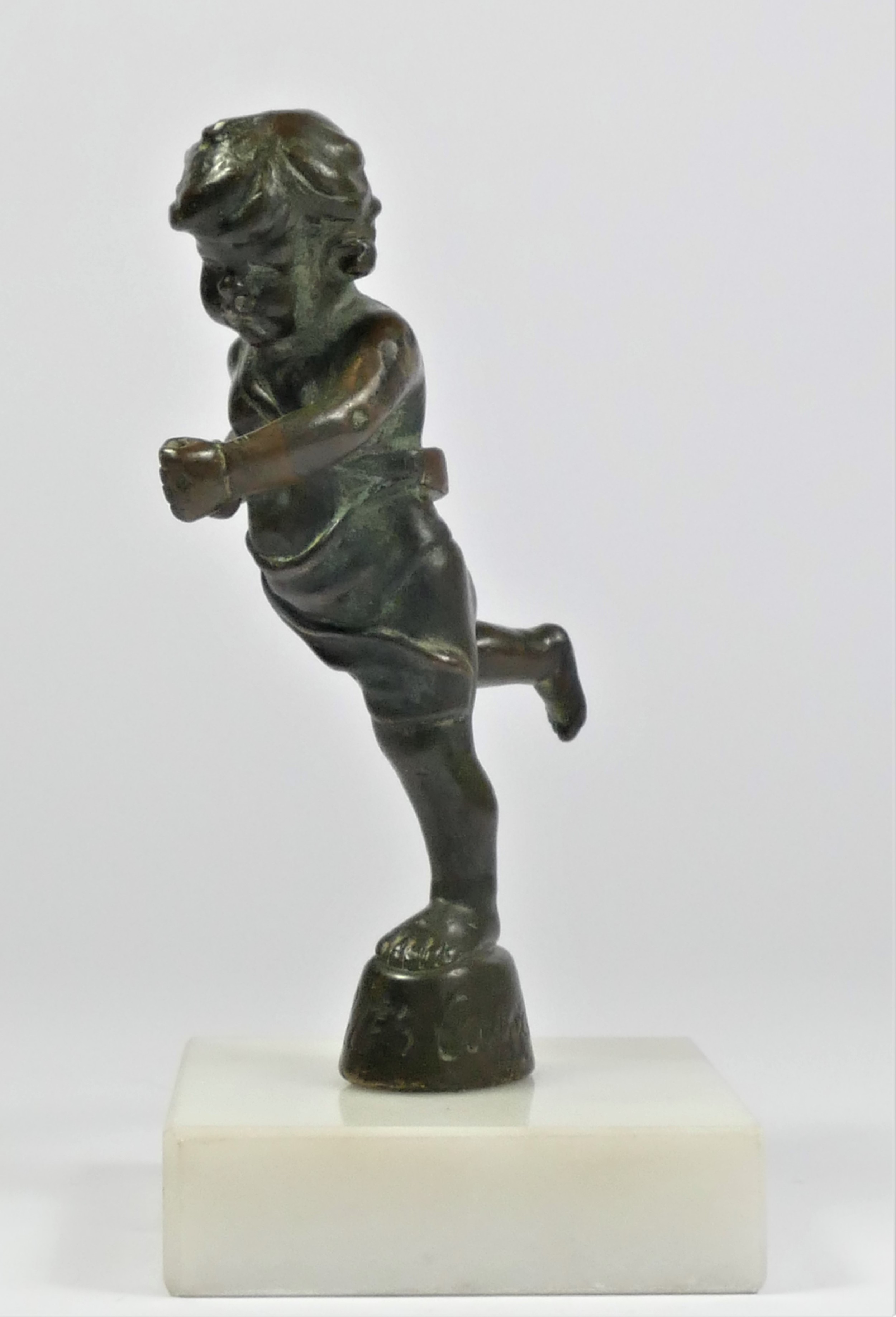 A bronze cherub car mascot signed Cubitt Cupid by Emile Lejeune, mounted on a white marble base, - Image 2 of 4