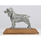 A chrome car mascot in the form of a Spaniel on a wooden base, 11cm.