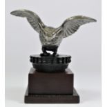 A chrome car mascot in the form of an owl mounted on a wooden base, 14cm.