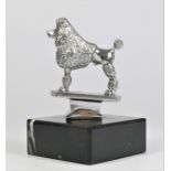 A chrome car mascot in the form of French Poodle, by A. G. Wand, mounted on a black onyx base, 12cm.