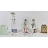 A Lladro porcelain figure of a seated boy together with two Nao figurines, a Swiza 8 day alarm