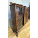 A mahogany display cabinet, having astragal glazed doors to each side to reveal three adjustable