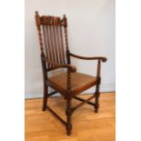 A Jacobean revival oak elbow armchair, early 20th Century having twin ball terminals to the top,