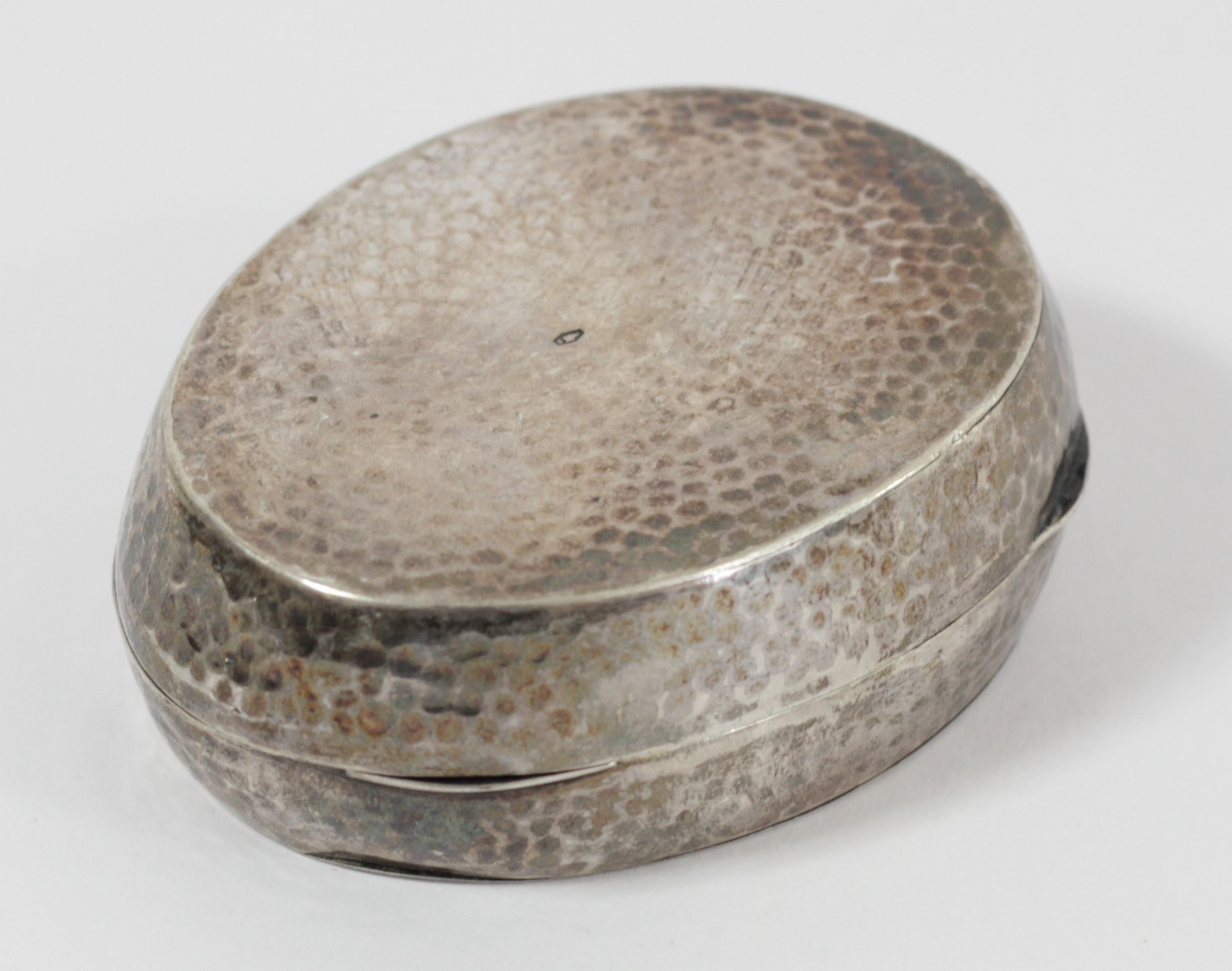 An 800 standard silver oval hammered box, bearing Austrian control marks, 7 x 5.5 x 2.5cm, 67gm