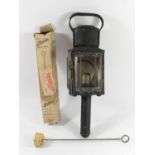 A candle burning coach lamp together with an original Aladdin lamp chimney cleaner, price marked 9D