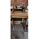 A Singer sewing machine (Y6255100), electric in a wooden case, on cast iron treadle, 95cm tall