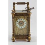 A late 19th century gilt brass carriage time piece, the ornate pierced floral dial with ivorine