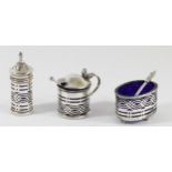 A silver three piece cruet, Birmingham 1920, with pierced decoration, blue glass liners.