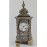 A Victorian cast silvered metal ornate mantle clock, white enamel dial to a French movement, the