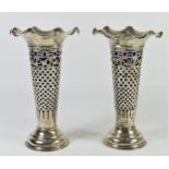 A silver pair of pierced vases by Jay, Richard Attenborough & Co Chester 1907, blue glass liners,