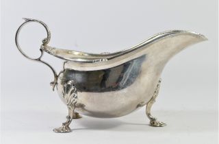 A silver gravy boat, by Walker & Hall, Sheffield 1937, with gadrooned border, leaf capped handle,