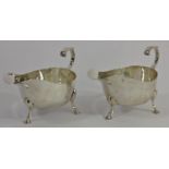 A silver pair of gravy boats, Sheffield 1919, of plain form with flying C scroll handles, raised