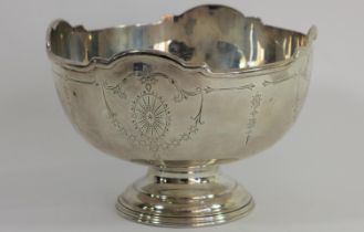 A silver bowl, Sheffield 1935, with applied border and bright cut engraved decoration, raised on a