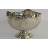 A silver bowl, Sheffield 1935, with applied border and bright cut engraved decoration, raised on a