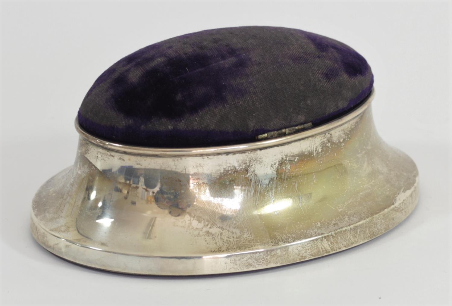 A silver mounted pin cushion/trinket box, Birmingham 1914, of oval form, the hinged lid opening to