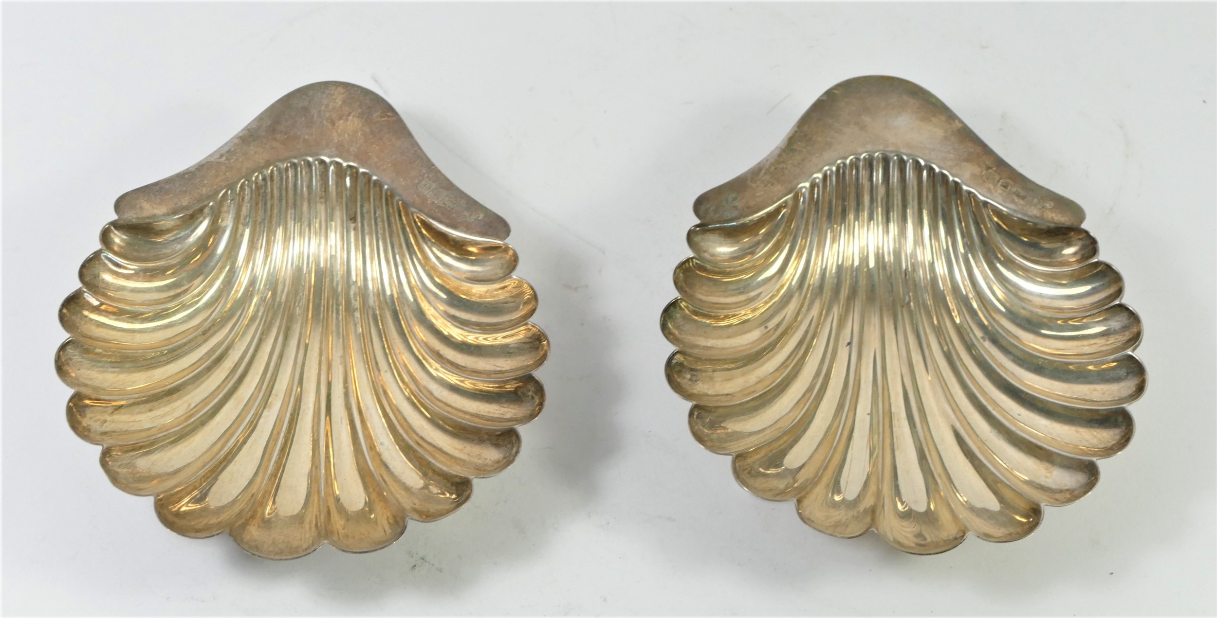 A pair of silver shell shape butter dishes, by Walker & Hall, London 1919, raised on three ball - Image 2 of 3
