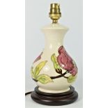 A Moorcroft Pink Magnolia tube lined pottery table lamp, mounted on a wood effect base, with