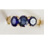 A gold and three stone sapphire ring, tests 18ct, claw set with oval mixed cuts stones, 6 x 5mm