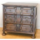 A late 17th century oak chest of three long drawers, two plank top over geometric moulded drawer