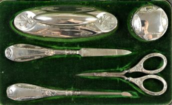 An Edwardian silver manicure set, Birmingham 1909, with embossed decoration, comprising, buffer,