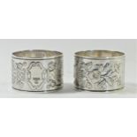 An Edwardian silver pair of napkin rings, Sheffield 1901, with applied and engraved flowers in a pot