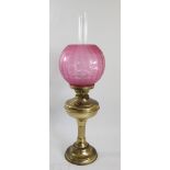 A brass oil lamp, with etched ruby glass shade, Sun clear glass funnel, 62cm