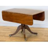 An early 19th century mahogany sofa table, raised on a turned pedestal, to a quatrefoil base, drawer