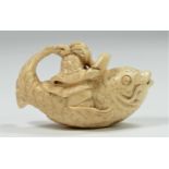 A Meiji period carved ivory netsuke of a wise man riding a fish, signed, 5.5cm