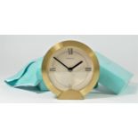 Tiffany & Co. a gilt brass circular quartz alarm clock, number 205738, diameter 88mm, pouch and box.