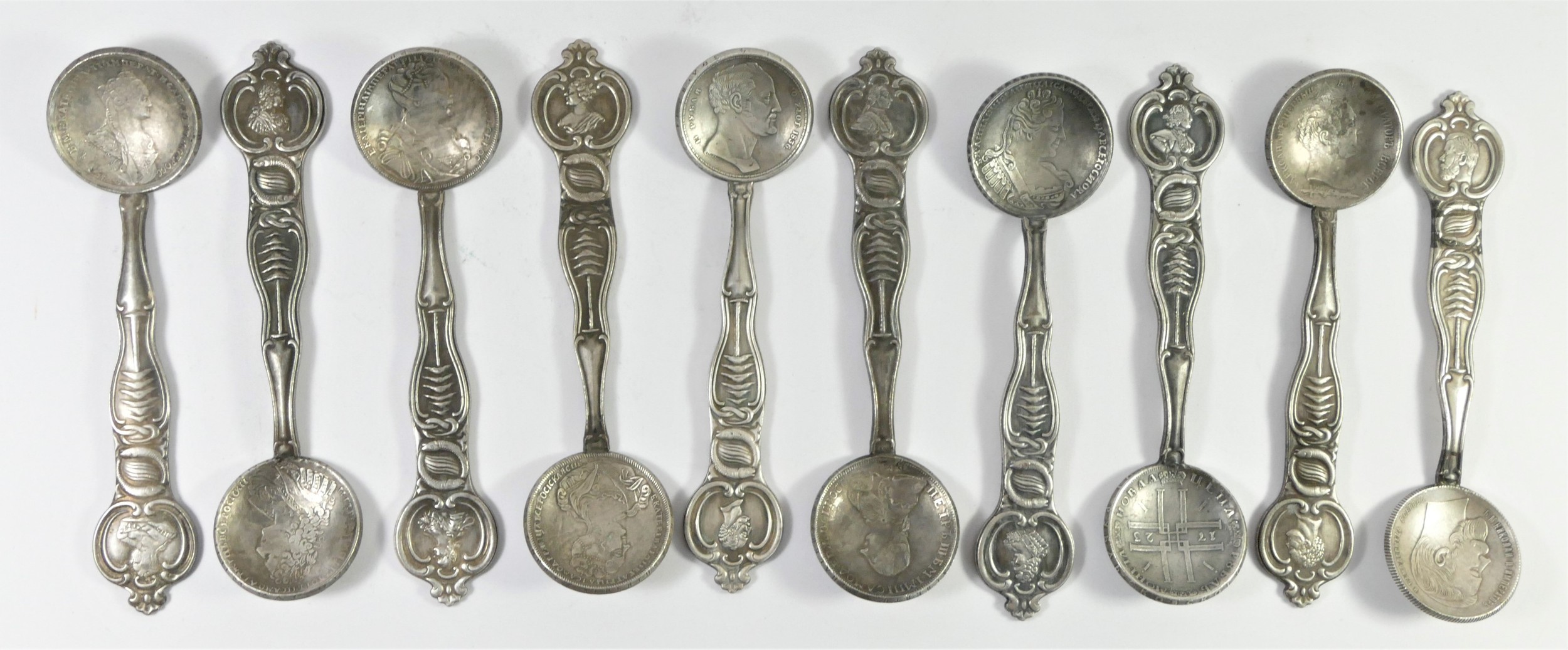 A base metal set of ten Russian style coin spoons, bearing pseudo silver hallmarks, each with a