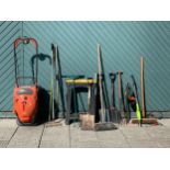 A collection of garden tools, including a Flymo Vision Compact 380, rakes, brooms, forks, spades,