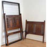 An early 20th Century oak bed, having Chinese inspired hand carved panels & turned spindles,